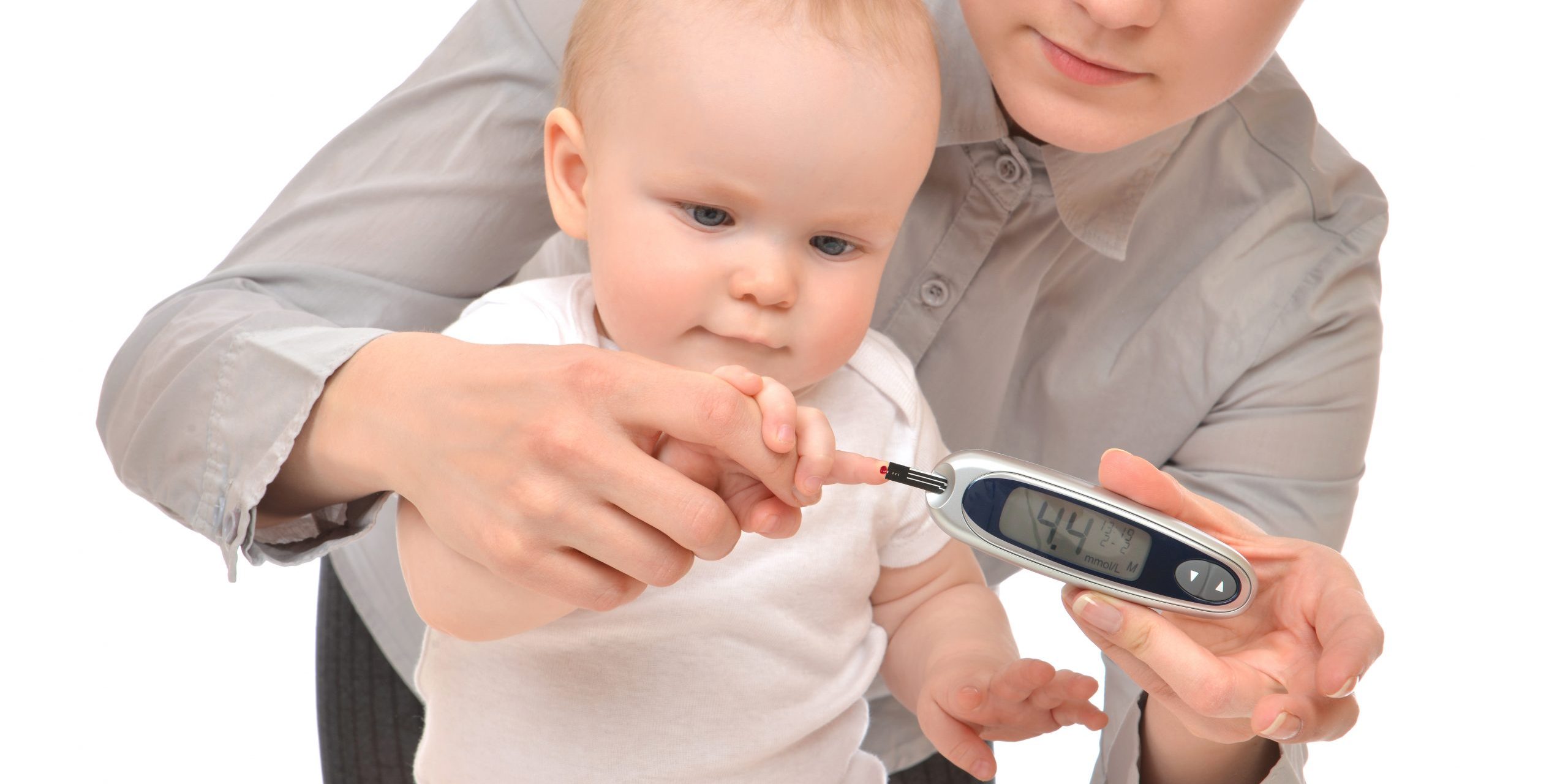 Matka mierząca poziom glukozy u małego dziecka z cukrzycą za pomocą glukometru